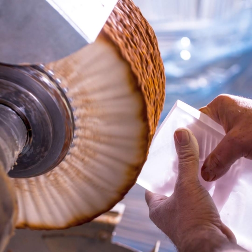 Midton craftsman polishing premium cast acrylic award during UK custom awards manufacturing process.