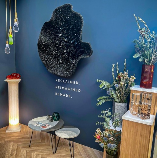 Show stand with vases, plants, lights, stands and black art shaped wall plaque