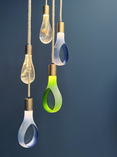 Five clear and translucent coloured acrylic bespoke lighting hanging on ropes with a blue background