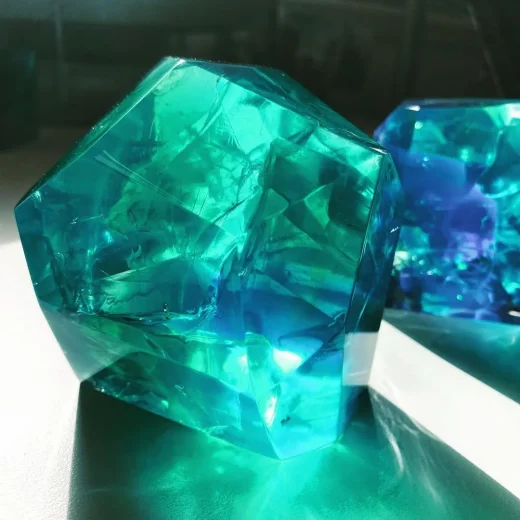 Translucent green and blue acrylic shards with light shining from the rear casting a shadow at the front for custom materials