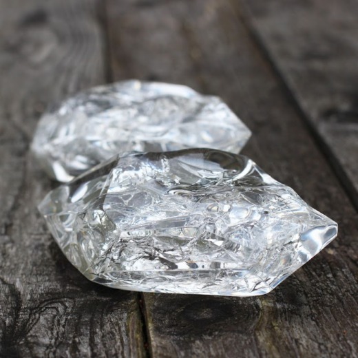 Clear acrylic shards with cracked and silver centres on a dark wood background for custom materials