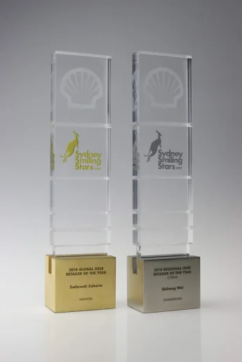 clear acrylic Shell corporate gifts with the Sydney Smiling Starts logo printed in silver and gold.