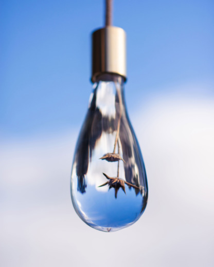 bespoke lighting droplet light with brass fixings hanging on ropes with sky in the background