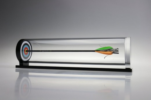 arrow in a clear acrylic tube mounted to a mini arrow board on a black base for product displays