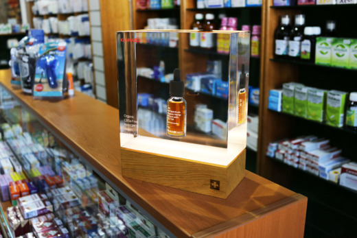 Kana Swiss clear acrylic and wooden LED illuminated bottle product displays in a chemist shop