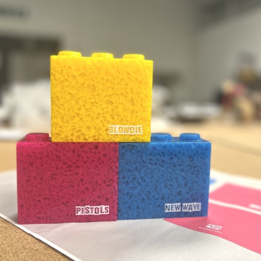 three coloured acrylic bricks with white text printed, blondie, pistols and new wave