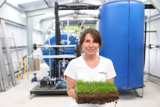 Midton employee holding Wrexham AFC pitch turf before acrylic encapsulation