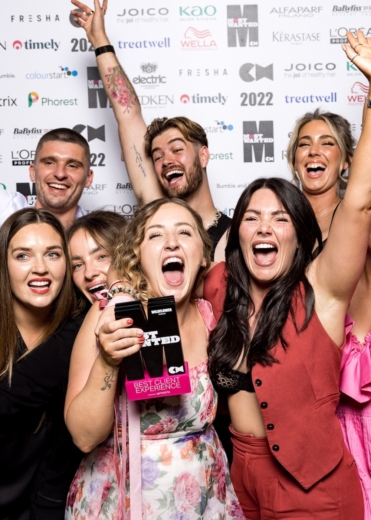 Group of winners celebrating with a custom acrylic Best Client Experience award manufactured by Midton