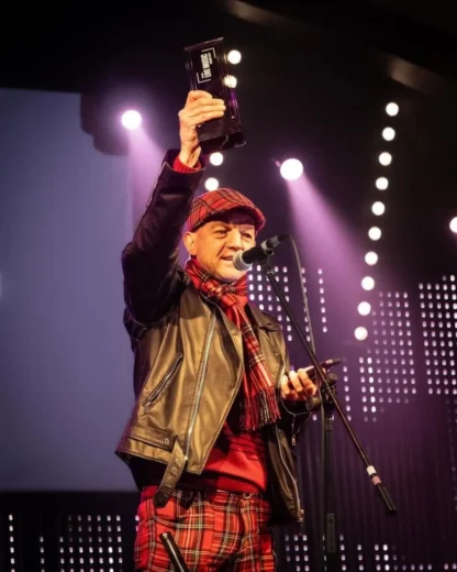 Winner holding bespoke Midton award during live stage presentation