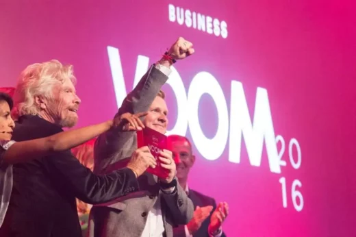Winners holding custom acrylic awards on stage at ceremony event