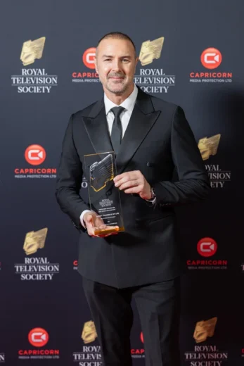 Royal Television Society award winner holding bespoke acrylic trophy