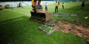 Excavator removing the historic Allianz Stadium pitch before Midton preserved sections for official England Rugby memorabilia.